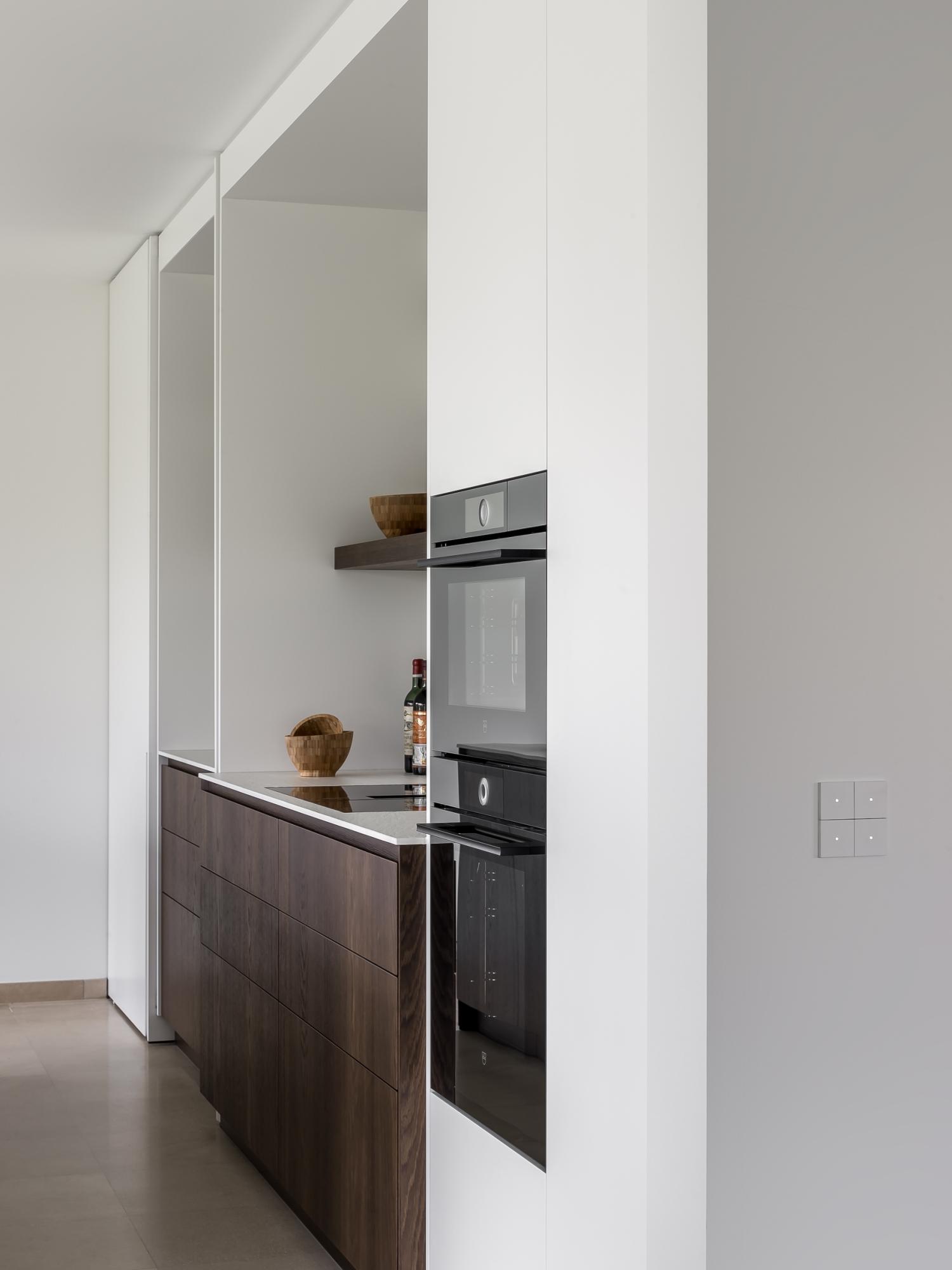 De lage zones werden bij deze keuken voorzien van een gerookte eik door Villa Interno